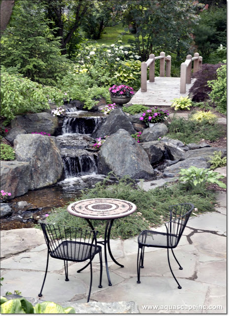 A simple patio with a bistro table creates a cozy, intimate spot for dining by the waterfalls.