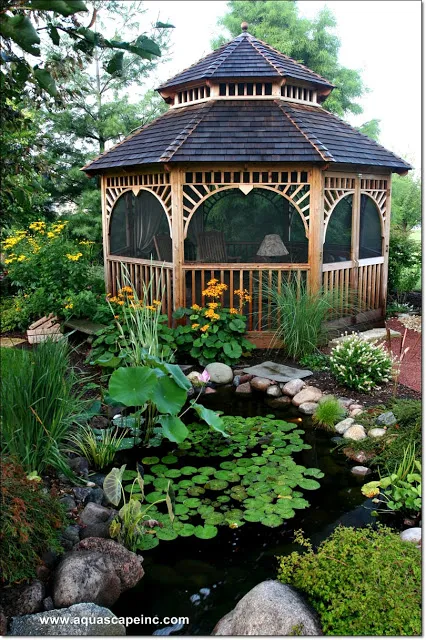 The charming gazebo provides an idyllic backdrop for a pond dotted with lily pads.