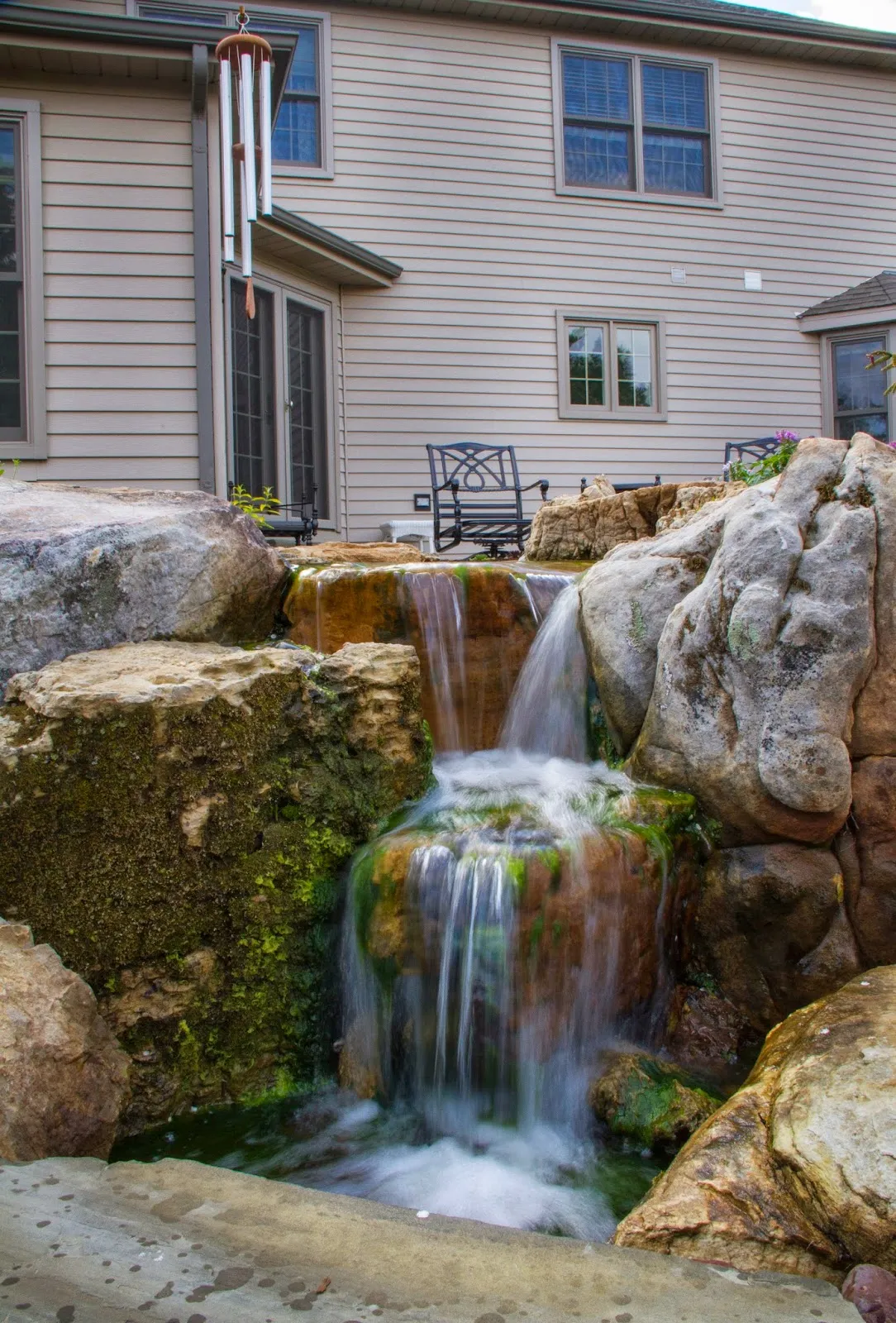 A mossy waterfall not only provides beauty but adds soothing sounds to this perfect backyard.