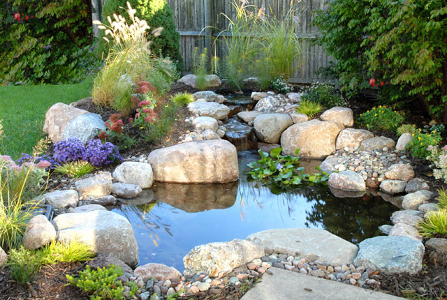 The waterfall is in proportion to this smaller pond, nestled snug against the corner of a patio.