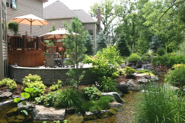 A multi-layered deck provides ample seating for festive gatherings by the waterfall and stream.