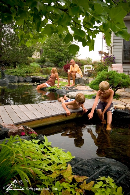 Family Enjoying an Aquascape Backyard Pond