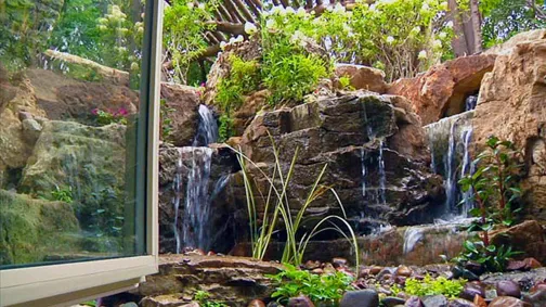 This rustic waterfall can be seen right outside the office window located in the home's lower level. 