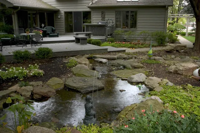 A gentle stream flows alongside the shady deck while a brass boy spitter provides an element of whimsy for those who linger and admire the scenery.